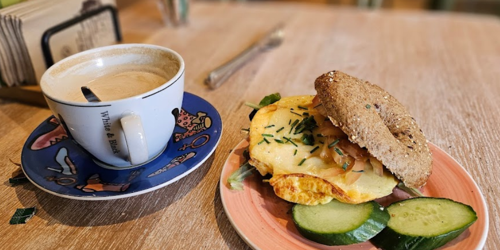 Bagels & Beans Roetersstraat Plantagebuurt bagel with eggs and a coffee cup