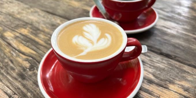 silo coffee berlin - a red cup of cappuccino and a red cup of coffee on a wood table